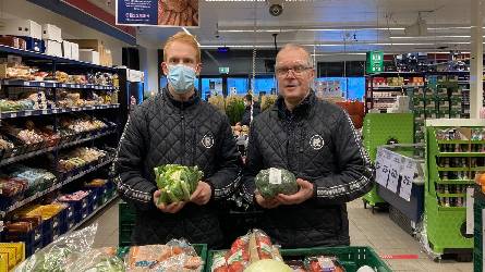 Store staff holding veg
